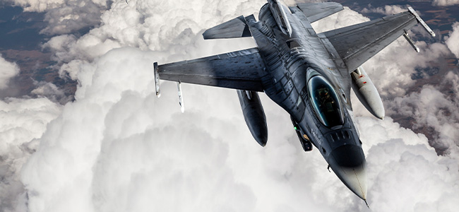 Aerospace fighter jet above clouds
